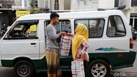 Sebuah angkot menurunkan nasi kotak untuk makan malam jamaah.