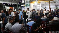 Jamaah antre mengambil menu makan malam yang disediakan masjid.