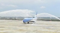 Tak lama setelah mendarat sebelum parkir di apron, tepatnya pukul 09.28 WIB, pesawat berbadan warna biru dan putih itu sambil melintas perlahan disiram oleh dua unit mobil penyiram dari kiri dan kanan.