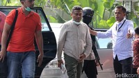 Ada masker yang tersemat di wajah Feisal, namun kemudian dibukanya. Dia tak berkata sepatah kata pun saat melintas masuk ke dalam gedung.