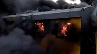 Sebuah rangkaian kereta terbakar saat mencapai sebuah stasiun di Cape Town, Afrika Selatan, pada Selasa (22/5/2018). Penyebab kebakaran belum diketahui namun tampak api dan asap tebal membubung dari sejumlah gerbong kereta. (Foto: Dok. Wardah Wilson via REUTERS)