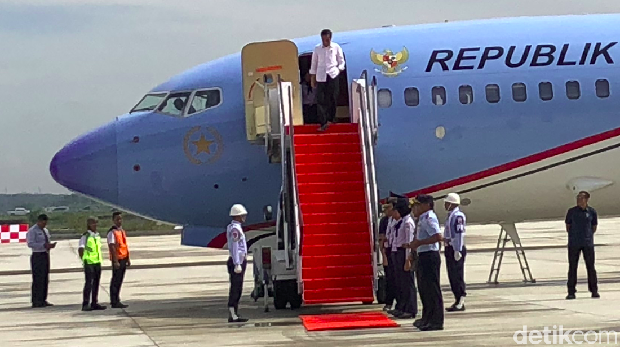 Jokowi menuruni tangga pesawat.