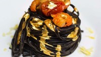 Pasta hitam dari tinta cumi ini, disajikan dengan udang, tomat ceri, perasan lemon, dan lapisan emas asli 24 karat. Foto: Istimewa