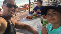 Berfoto dengan sang anak. Happy Salma justru terlihat asyik menikmati makanannya di pinggir pantai. Foto: Instagram @tjokgus