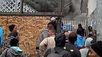 Api dan asap tebal muncul dari gerbong bagian tengah kereta dan menjalar ke gerbong lainnya. (Foto: Dok. Wardah Wilson via REUTERS)
