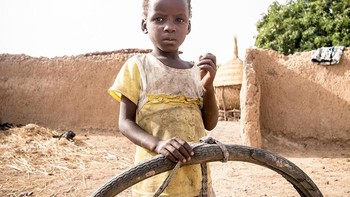 Orang tua anak ini di Burkina Faso menghasilkan USD 29 per bulan. Mainan favoritnya adalah ban usang. Foto: Gapminder