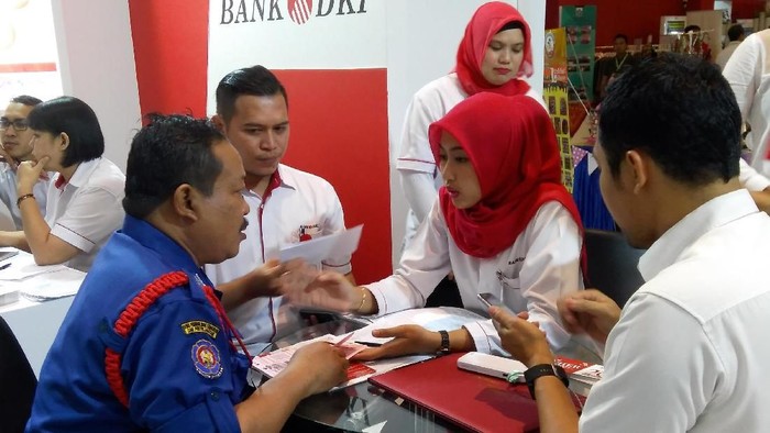 Karyawan Bank DKI tengah menjelaskan aplikasi JakOne Mobile kepada pengunjung Pekan Raya Jakarta di Jakarta (23/5/2018).