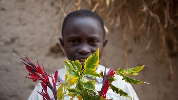 Anak di Rwanda dengan penghasilan orang tua USD 72 per bulan memegang daun mainannya. Foto: Gapminder