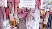 Salah seorang pedagang memperlihatkan mukena yang dipasarkannya.