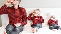 Tiga jagoan Kate pakai kemeja kotak-kotak merah hitam sedang pose minum di tempat tidur. Eits, tapi kok sang bayi malah gigit tangan aja? Foto: Instagram kweilz