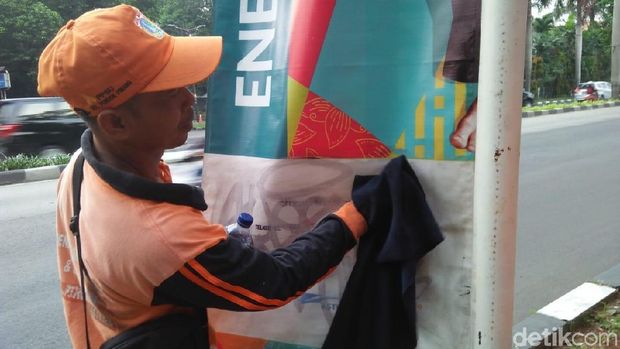 Pasukan oranye membersihkan coretan banner Asian Games di Pondok Indah, Jaksel, Jumat (25/5/2018)