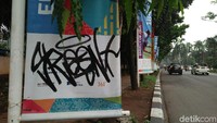 Banner yang dicoret-coret itu tak selalu berderet tapi terpencar. Bentuk coretan berbeda-beda, tidak ada yang berbentuk gambar atau kata.