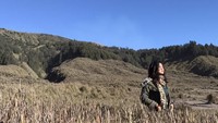 Di kesempatan lain, Dinda menikmati keindahan Taman Nasional Bromo Tengger Semeru. Dia berfoto di padang savana. (Instagram/Dellie Dinda)