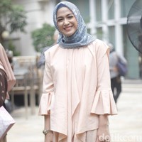 Nina Zatulani memakai warna senada dengan Nycta Gina. Ia memilih tunik dengan aksen layering di bagian depan dan lengan lonceng. Ia padukan tunik tersebut dengan hijab segi empat motif bercorak geometris yang merupakan bagian dari koleksi terbaru Pelangi Asmara. Foto: Silmia Putri/Wolipop