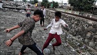 Mereka bermain bola sambil menunggu waktu berbuka.