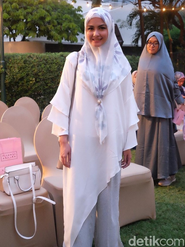 Revalina S. Temat tampak sangat anggun memakai tunik berwarna putih dipadukan dengan hijab segi empat berwarna senada. Tunik yang ia kenakan memiliki potongan asimetris dengan aksen lengan lonceng. Foto: Silmia Putri/Wolipop