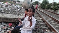 Mereka terpaksa bermain bola di pinggir rel, karena tidak pun lapangan bola.