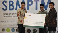 Direktur Utama Mandiri Syariah Toni EB Subari (kiri) menyerahkan bantuan untuk mahasiswa kurang mampu Perguruan Tinggi Muhammadiyah dan Aisyiyah kepada Ketua Majelis Diktilitbang PP Muhammadiyah Lincolin Arsyad (kanan) disaksikan Ketua Umum Pimpinan Pusat (PP) Muhammadiyah Haedar Nashir (kedua kiri). Dok.Bank Mandiri Syariah