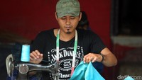 Salah satu penjahit tengah mengerjakan permak pakaian.