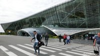 Foto: Para traveler keluar dari Terminal 1. Bentuk fasad bandaranya bergelombang, dengan dinding kaca semua (Hany/detikTravel)