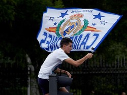 Salah satu fans tampak naik ke lampu lalu lintas untuk bisa melihat dengan jelas skuat Real Madrid. (Foto: Gonzalo Arroyo Moreno/Getty Images)