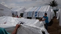 Beberapa relawan terlihat sedang membangun tenda pengungsian untuk menjadi tempat tinggal sementara para pengungsi. Jes Aznar/Getty Images.