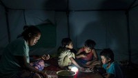 Sebuah keluarga pengungsi sedang bersantap sahur di pengungsian. Jes Aznar/Getty Images.