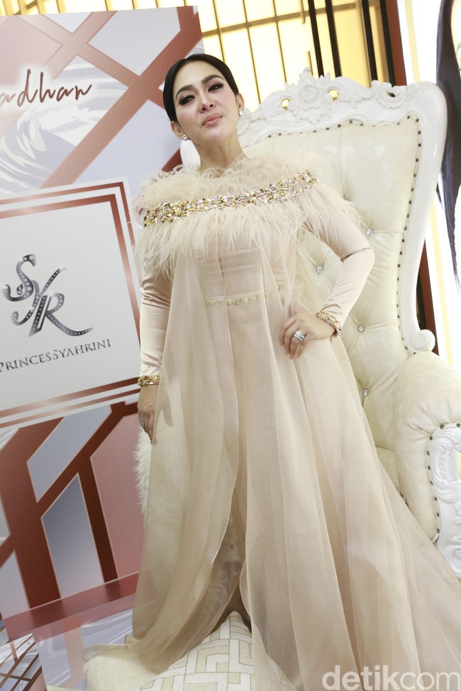 Dalam acara Lakme Illuminating Ramadan Makeup, Syahrini tampil dengan gaun panjang putih yang dilapisi dengan tulle panjang menyeret lantai. Tampilan semakin glamour dengan bulu-bulu manja di bagian atas. Aku tampilan Lebaran kayak hari ini aja, ucap pemilik jargon maju mundur cantik itu. Foto: Palevi S/detikHOT