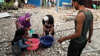 Warga korban gusuran ini tengah menyiapkan air bersih yang dialiri dari salah satu sumber air.
