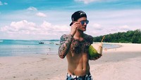 Bertelanjang dada, pesepak bola berusia 24 tahun ini terlihat sedang menikmati air kelapa langsung dari batoknya di pinggir pantai. Foto: Instagram @lorisk21