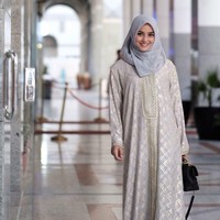 Artis Ririn Ekawati terlihat mengenakan gamis bermotif berwarna abu-abu dan emas saat menjalankan ibadah umrah. Agar penampilannya tidak terlalu mencolok, Ririn memadukan busananya itu dengan kerudung polos berwarna abu-abu. Foto: Dok. Instagram