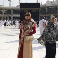 Vicky Shu tampil dengan gaya busana tumpuk saat umrah. Vicky memadukan gamis merah dengan vest panjang berwarna cokelat saat berpose di depan Kabah. Dia juga terlihat bergaya membawa tas Christian Dior. Foto: Dok. Instagram