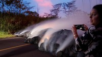Seorang wartawan mengambil gambar aliran lava Kilauea yang melintasi Jalan Pohoiki dekat Jalan Raya 132, Pahoa, Hawaii, dengan jarak super dekat.  (Foto: Dok. REUTERS/Marco Garcia)