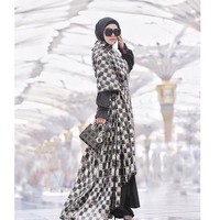 Tampil glamour saat umroh juga pernah dilakukan oleh penyanyi Syahrini saat umrah bersama First Travel. Berpose di halaman Masjid Nabawi, Syahrini terlihat glamour memakai busana rancangan Anniesa Hasibuan. Terdiri dari gaun dan outerwear gelap nan mengilap, busana itu dipadu dengan tas Lady Dior yang ikonis itu. Foto: Dok. Instagram