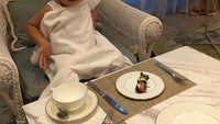 Saat El baru berusia 2 tahun, ia sudah menikmati high tea lho. Lihat saja gayanya di depan makanan dan cangkir teh yang terlihat besar. Foto: instagram @alexanderbarackel