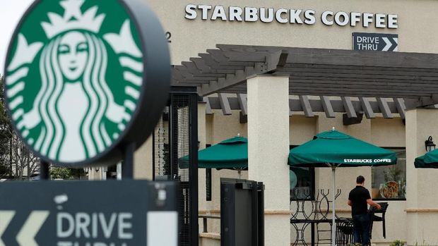 A worker puts away patio furniture at a Starbucks Corp drive-through location closes down this afternoon for anti-bias training as the coffee chain closed all 8,000 of their company-owned cafes in the US including this location in Oceanside, California, U.S. .  May 29, 2018. REUTERS/Mike Blake