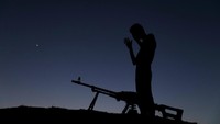 Meski sedang salat, terlihat senjata tak pernah jauh dari mereka untuk berjaga jika ada serangan mendadak. Foto: REUTERS/Alaa Al-Faqir