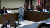 Yulianis berjalan ke ruang sidang usai memperlihatkan wajahnya di dekat pintu hakim. Dia memperlihatkan wajahnya atas permintaan jaksa.