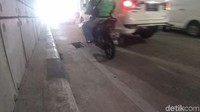 Motor dan mobil tetap melintas di underpass.