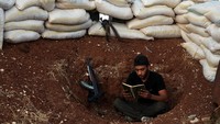 Mereka juga membaca Alquran dengan senjata yang berada di dekat mereka. Foto: REUTERS/Alaa Al-Faqir