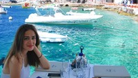 Mengunjungi Santorini, Yasmin pun terlihat cantik duduk di pinggir laut sambil menunggu seafoodnya datang. Foto: Instagram @yaswildblood