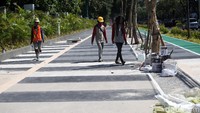 Sejumlah pekerja terus melakukan perbaikan pedesterian.