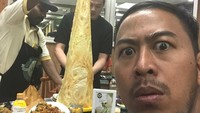 Benda aneh ini adalah makanan enak, tulis Panji. Ia bahkan berfoto di depan roti tisu yang tinggi mengerucut. Wajahnya menggambarkan Panji belum pernah melihat makanan ini sebelumnya. Foto: instagram @pandji.pragiwaksono