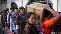 Porter membantu membawakan barang milik penumpang.