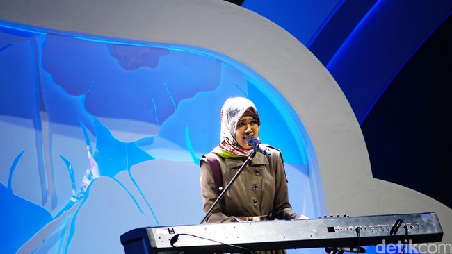 Riski Makarima asal Ngawi yang terpilih sebagai juara Sunsilk Hijab Hunt 2018 terfavorit, bernyanyi sambil bermain piano di malam grand final. Foto: Niko W/detikcom