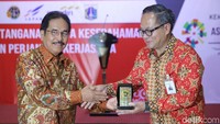 Menteri Agraria & Tata Ruang/Kepala Badan Pertanahan Nasional Sofyan A Djalil dan Direktur Utama Bank Mandiri Kartika Wirjoatmodjo bertukar cenderamata.