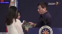 Dia kemudian memanggil dua perempuan muda ke atas panggung dan memberikan mereka sebuah buku. 