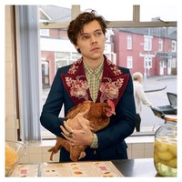 Pose bersama seekor ayam, penampilan Harry Styles yang tampak eklektik dengan jaket New Marseille Gucci yang dibuat khusus untuknya. Jaket terlihat stylish dan fancy berhias bordiran bunga pada kerahnya. Foto: Getty Images