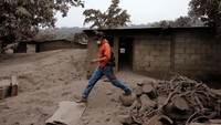 Tim SAR menyusuri desa yang tertutup abu vulkanis Gunung Fuego. Reuters/Luis Echeverria.