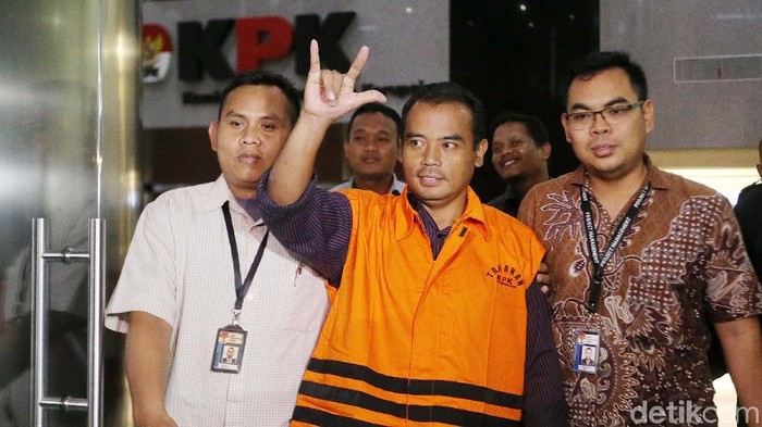 Bupati Purbalingga Tasdi kembali mengacungkan salam metal. Kali ini salam metal itu ditunjukkannya setelah resmi ditahan KPK.